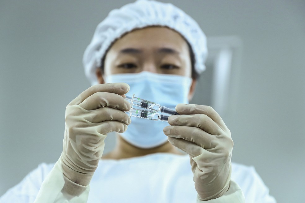 Funcionário inspeciona doses no Instituto de Produtos Biológicos de Pequim, que desenvolve o imunizante com a Sinopharm — Foto: Zhang Yuwei/Xinhua via AP/Arquivo