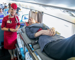 Deitada, mulher mais alta do mundo viaja de avião pela primeira vez