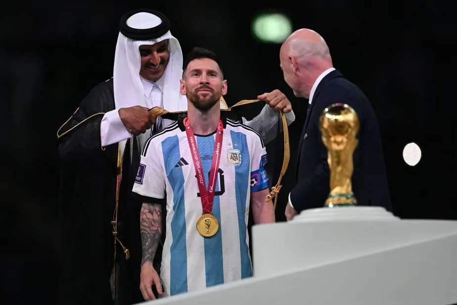 Emir Sheikh Tamim bin Hamad al-Thani veste Messi com um manto chique como o seu, em seda preta com detalhes em dourado, em homenagem ao destaque do Mundial - Foto: AFP